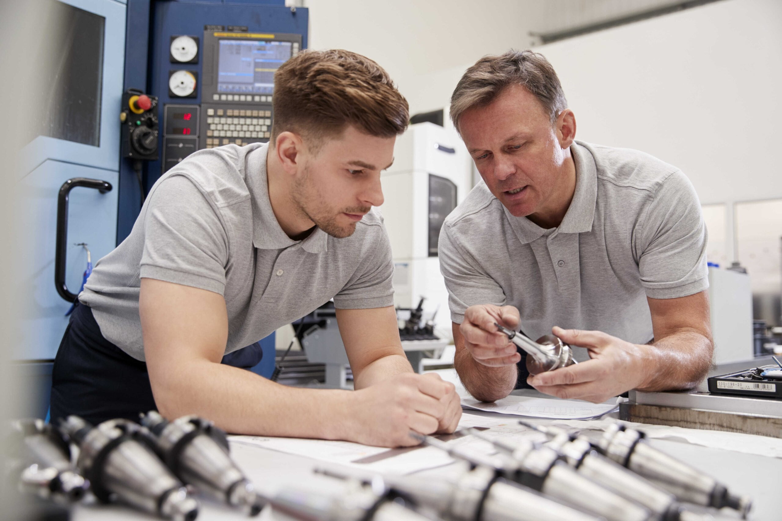 Two engineers doing quality checks on steel components
